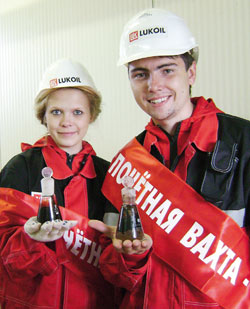 на трудовой вахте с добытой нефтью молодые специалисты М. Мамонтова и И. Бурмистров