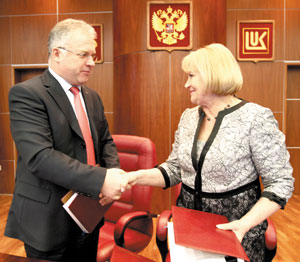 П. Оборонков и Т. Полякова обмениваются папками с подписанным документом