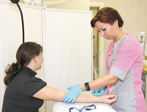 Медсестра процедурного кабинета Н. Регентова производит забор крови