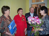 чету Ломако (в центре) поздравляет председатель совета ветеранов-нефтяников Ухты С. Шарандина (слева)